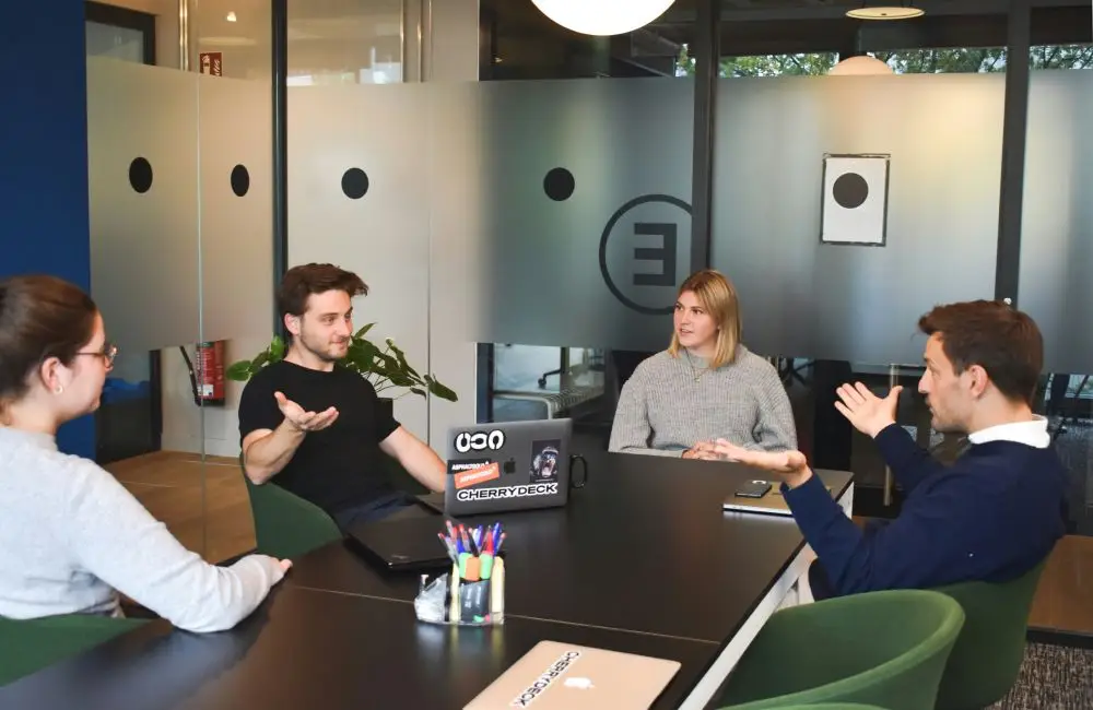 Small business team discussing workflow, decisions, and business operations around a table